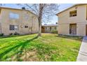Lawn area behind an apartment building and units with light-colored walls at 3821 1/2 Daisy St # 26, Las Vegas, NV 89119