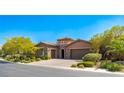 Beautiful single-story home featuring lush landscaping, a paver driveway, and a three-car garage at 47 Grand Masters Dr, Las Vegas, NV 89141