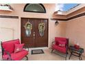 Inviting front entry with double doors, decorative wreaths, and comfortable seating area at 5528 Apache Wells Way, Las Vegas, NV 89130