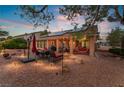 Relaxing outdoor patio with comfortable seating, solar panels, and a well-maintained gravel landscape at 5528 Apache Wells Way, Las Vegas, NV 89130