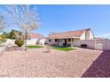 Spacious backyard featuring low maintenance landscaping, a covered patio, and a storage shed at 5927 Tropical Palm Ct, North Las Vegas, NV 89031