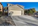Two-story home with desert landscaping, two-car garage, and a long concrete driveway at 6104 Talbot Springs Ct, North Las Vegas, NV 89081