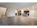 Open-concept living area with wood-look floors leading to a modern kitchen at 6129 Rose Springs Ave, Las Vegas, NV 89130