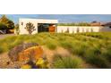 Expansive front yard of contemporary home boasts desert landscaping with succulents and a statement boulder at 7030 Schirlls St, Las Vegas, NV 89118