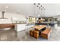 Bright open-concept kitchen and living area featuring modern appliances and a unique wooden dining table at 7030 Schirlls St, Las Vegas, NV 89118