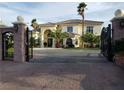 A stately residence, showcased through an ornate gate, features lush landscaping and an inviting facade at 7261 Obannon Dr, Las Vegas, NV 89117