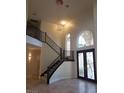 A soaring two-story foyer features a staircase, large arched window, and decorative glass front doors at 7261 Obannon Dr, Las Vegas, NV 89117
