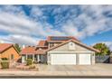 Two-story home with red tile roof, desert landscaping, three-car garage, and solar panels on the roof at 8304 Esmont Ln, Las Vegas, NV 89117