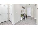 Bright entryway with neutral walls, tiled floor, bench, and decorative accents at 9675 Bold Skye Ave, Las Vegas, NV 89166