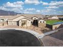 Aerial view of a single-Gathering home with desert landscaping, a three-car garage, and a sports court at 10420 Luella Ct, Las Vegas, NV 89143