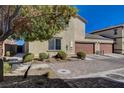 Two-story home boasts a brown two-car garage, stucco exterior, and a brick paver driveway for added curb appeal at 1055 Admiral Emblem St, Henderson, NV 89015