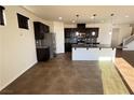 The kitchen features stainless steel appliances, dark cabinets, and granite countertops with an island at 10715 York Manor Ave, Las Vegas, NV 89166