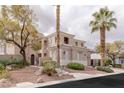 Elegant two-story home featuring a stucco exterior, lush landscaping, and mature palm trees at 11241 Golden Chestnut Pl, Las Vegas, NV 89135