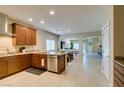 Well-lit kitchen with wooden cabinets, granite counters, stainless steel appliances and an island at 124 Strone St, Henderson, NV 89012