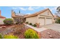 Single story home with two-car garage, desert landscaping, and tile roof at 213 Red Coral Dr, Henderson, NV 89002