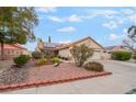 Single story home with a two-car garage, tile roof and desert landscaping at 213 Red Coral Dr, Henderson, NV 89002
