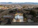 Wide aerial view of the property showcasing the pool, landscaping, and neighborhood with mountain backdrop at 2281 Wagon Ave, Pahrump, NV 89048