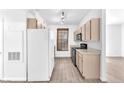 Well-lit kitchen with white fridge, wood cabinets, and modern appliances for a convenient cooking experience at 231 W Horizon Ridge Pkwy # 812, Henderson, NV 89012