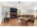 Cozy living room features a brick fireplace, plantation shutters, and tile flooring for a warm and inviting atmosphere at 3040 Ocean Port Dr, Las Vegas, NV 89117