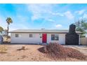 Single-story home features a red front door, palm tree, and a rock chimney at 4980 Becky Pl, Las Vegas, NV 89120