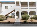 Condo building featuring a stucco facade, private balconies, and rock landscaping at its entryway at 5655 E Sahara Ave # 1060, Las Vegas, NV 89142