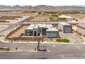 Expansive aerial view of a contemporary home with multiple garages, desert landscaping, and mountain backdrop at 5719 Christian Creek Ct, Las Vegas, NV 89149