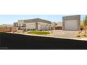 Modern home featuring multiple garage spaces, desert landscaping, and sleek contemporary design at 5719 Christian Creek Ct, Las Vegas, NV 89149