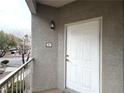 Apartment 207 front door with exterior light fixture and view of courtyard at 6160 Rumrill St # 207, Las Vegas, NV 89113