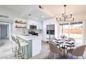 Updated kitchen with stainless steel appliances, white cabinets, and an island with seating, plus adjacent dining space at 6170 W University Ave, Las Vegas, NV 89103