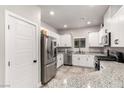 Modern kitchen boasts stainless steel appliances, granite countertops, and ample white cabinetry at 7457 Onyx Star St, North Las Vegas, NV 89084
