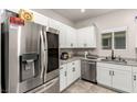 Modern kitchen featuring stainless steel appliances, light granite countertops, and white cabinetry at 7457 Onyx Star St, North Las Vegas, NV 89084