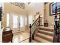 Bright foyer features staircase, high ceilings, tile and carpet flooring and double glass doors at 1013 Baronet Dr, Las Vegas, NV 89138