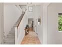 Bright entryway featuring tile flooring, a staircase with white railings, and natural light from the window at 11344 Espadrille Ct, Las Vegas, NV 89138