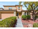 Charming two-story home featuring a terra-cotta roof, attached garage, and desert landscaping at 11344 Espadrille Ct, Las Vegas, NV 89138