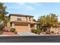 Charming two-story home featuring a terra-cotta roof, attached garage, and desert landscaping at 11344 Espadrille Ct, Las Vegas, NV 89138