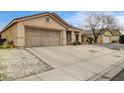 Single-story home with a two-car garage, desert landscaping, and a long driveway at 2308 Avery Dr, Las Vegas, NV 89108