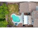 Aerial view of a private backyard featuring a kidney shaped swimming pool, patio area, and lush lawn at 2374 Falsetto Ave, Henderson, NV 89052