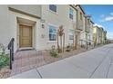 A modern townhome exterior with brick steps leading to a front door at 2949 White Selzter Ct, Las Vegas, NV 89122