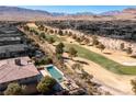 An aerial view of the community golf course with a home, pool, and spa in the foreground at 30 Meadowhawk Ln, Las Vegas, NV 89135