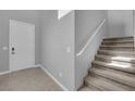 Bright entryway featuring neutral paint, tile floors, and a staircase leading to the upper level at 3192 Timorasso Ave, Henderson, NV 89044