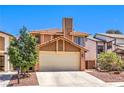 Attractive home featuring a well-manicured lawn, attached garage, and charming architectural details at 361 Tobler Dr, Las Vegas, NV 89145