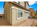 Home exterior with paved driveway, rock landscaping, and privacy gate at 382 Scarlet Pine Ct, Henderson, NV 89044