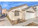 Beige single-story home featuring a two-car garage and simple landscaping under a clear, blue sky at 4381 Coyote Crest Ct, Las Vegas, NV 89147