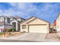 Beige single-story home with a two-car garage, surrounded by neighboring houses and a clear sky at 4381 Coyote Crest Ct, Las Vegas, NV 89147