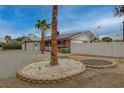 This home features a well-maintained front yard with desert landscaping and mature palm trees at 4678 San Benito St, Las Vegas, NV 89121