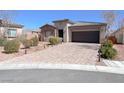Beautiful single-story home with a paver driveway, desert landscaping, and an attached two-car garage at 5555 E San Pietro Dr, Pahrump, NV 89061