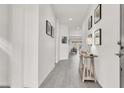 Bright hallway with light-grey wood-look flooring, white walls and stylish decor at 5555 E San Pietro Dr, Pahrump, NV 89061
