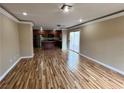 Spacious living room featuring wood floors that seamlessly connects to an open kitchen with sliding door access to the patio at 566 Shewsbury Ave, Las Vegas, NV 89178