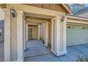 Covered front porch featuring sturdy support columns, outdoor lighting, and convenient access to the two-car garage at 5916 Sierra Cliff St, North Las Vegas, NV 89031