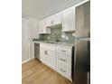 Updated kitchen with white cabinets, stainless steel appliances, and stylish backsplash at 604 N Minnesota St, Las Vegas, NV 89107